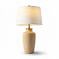 Ceramic table lamp with textured base and fabric shade in cream color